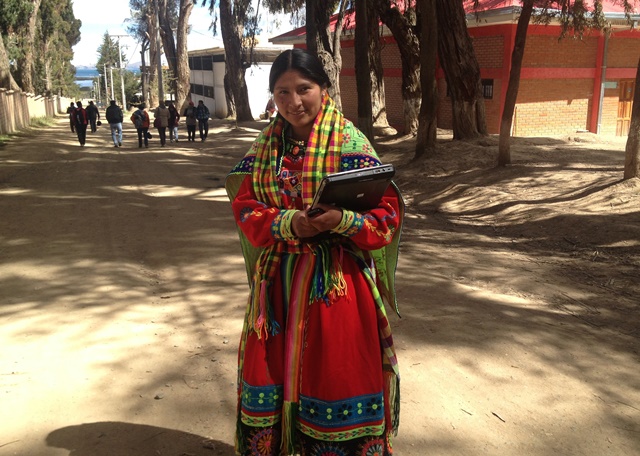 Estudiante en traje festivo y con una laptop en las manos.