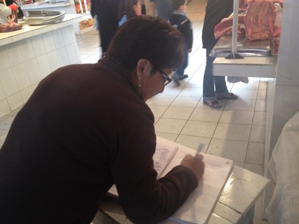 Una &quot;casera&quot; firma el libro con el que los vendedores del mercado Kollasuyo intentan reunir apoyo para que los comerciantes callejeros ingresen en el edificio de Villa Copacabana